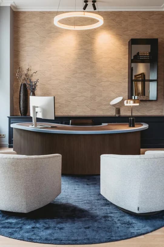 Kantoor met ontvangstbalie en fauteuils voor een wand met behang van Arte
