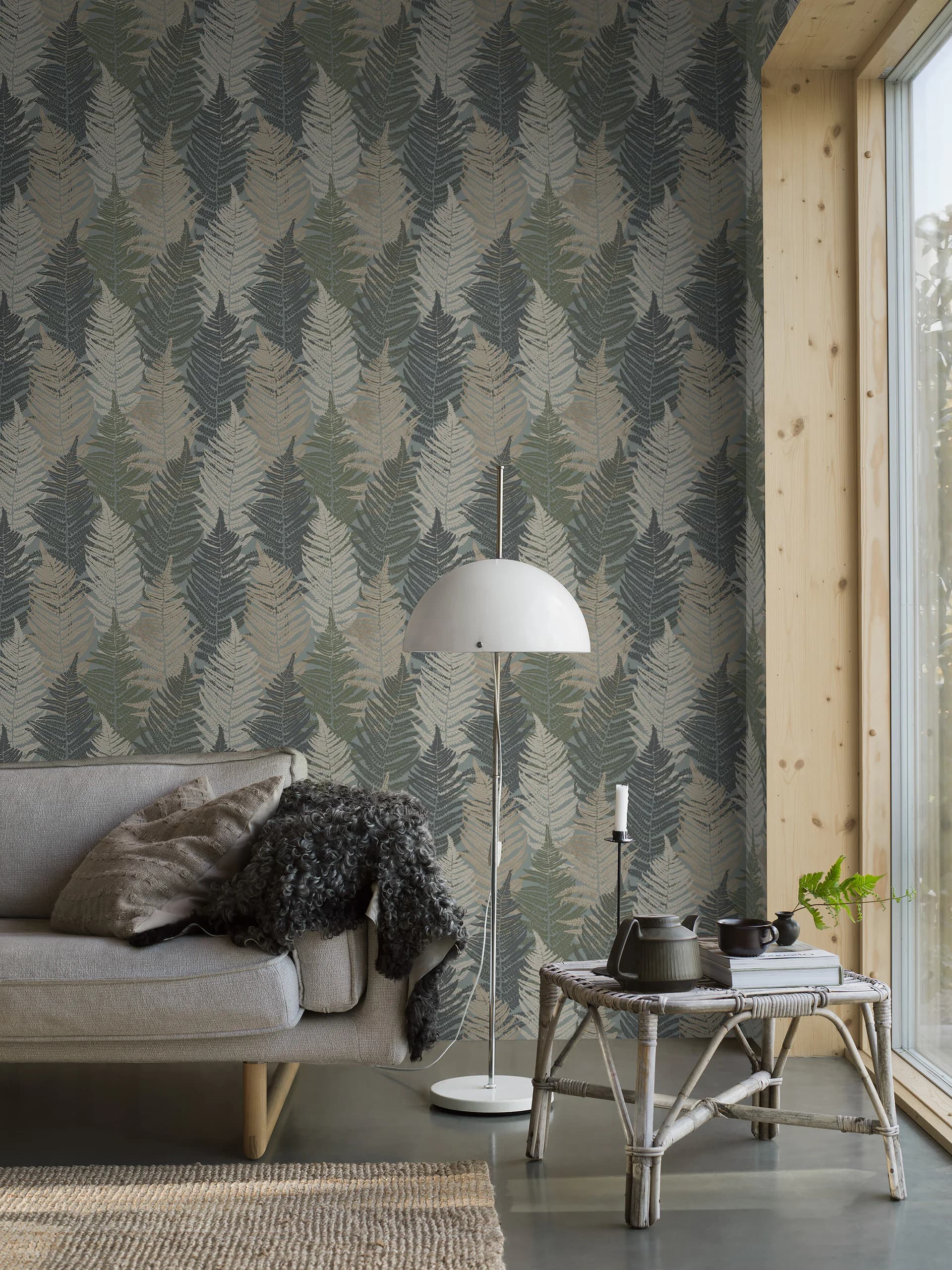 Woonkamer met groen varenbehang, bank en vloerlamp