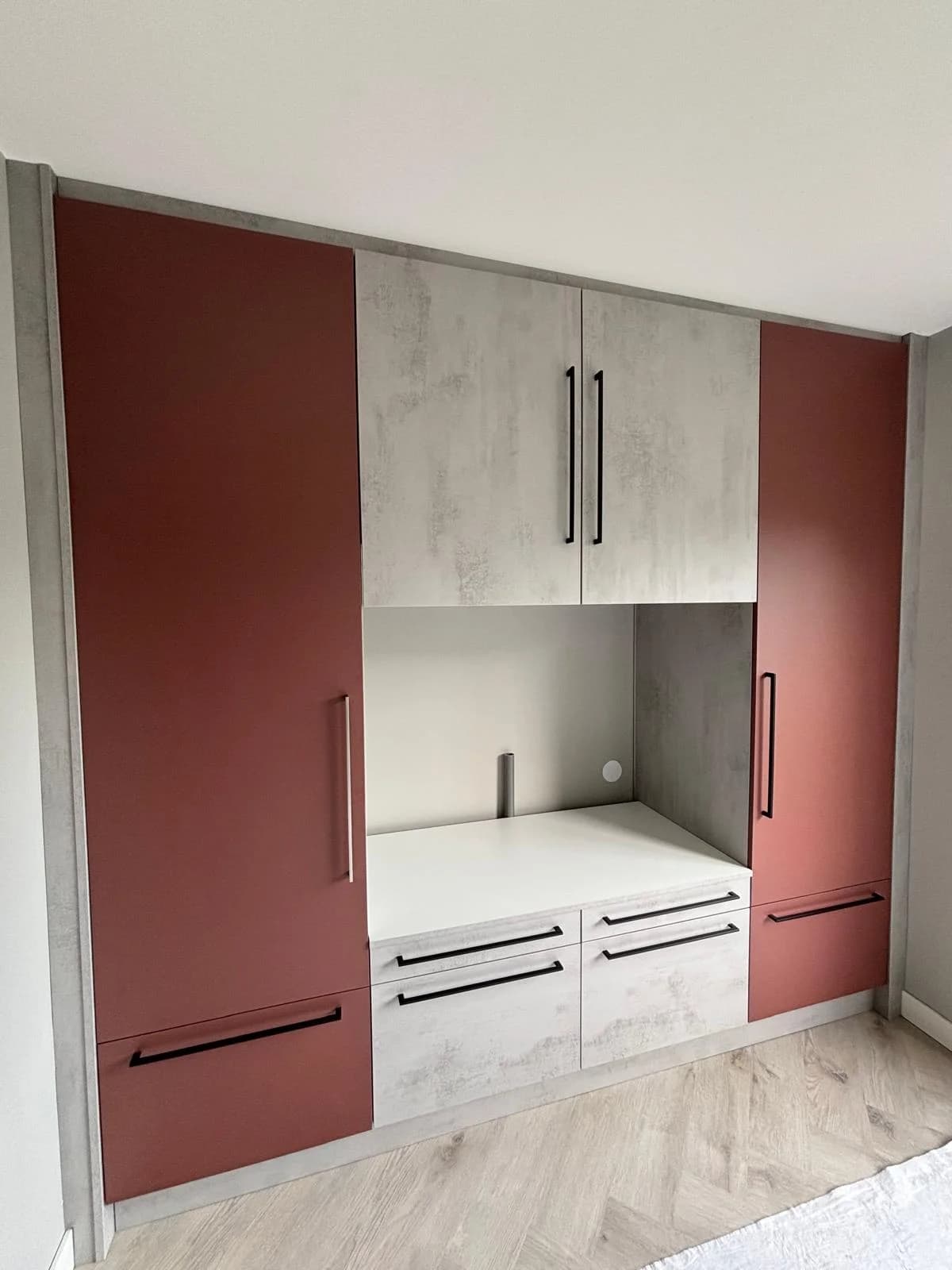 Kastenwand op maat met rode deuren en een middendeel in betonlook