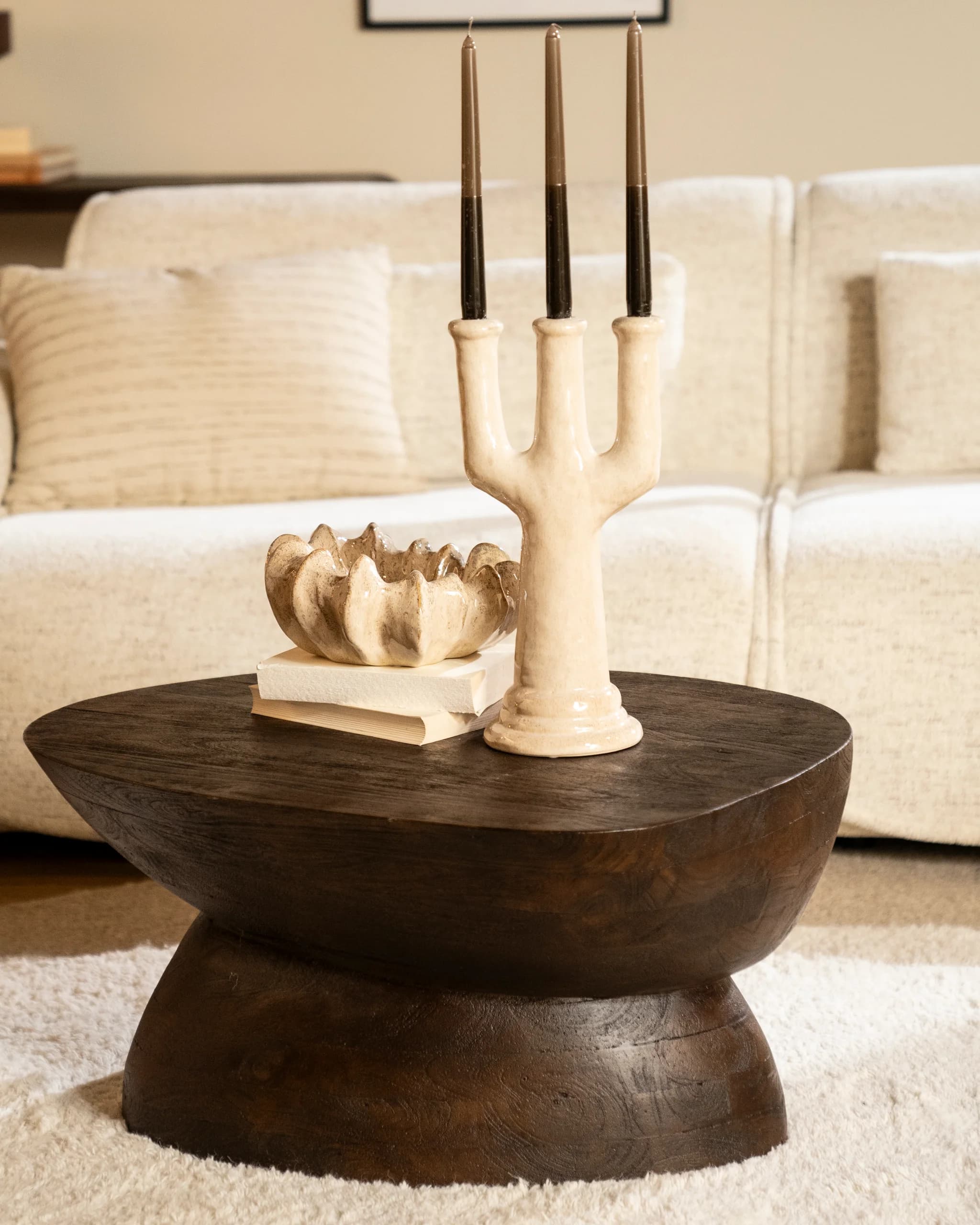 Houten bijzettafel met kandelaar voor een witte bank