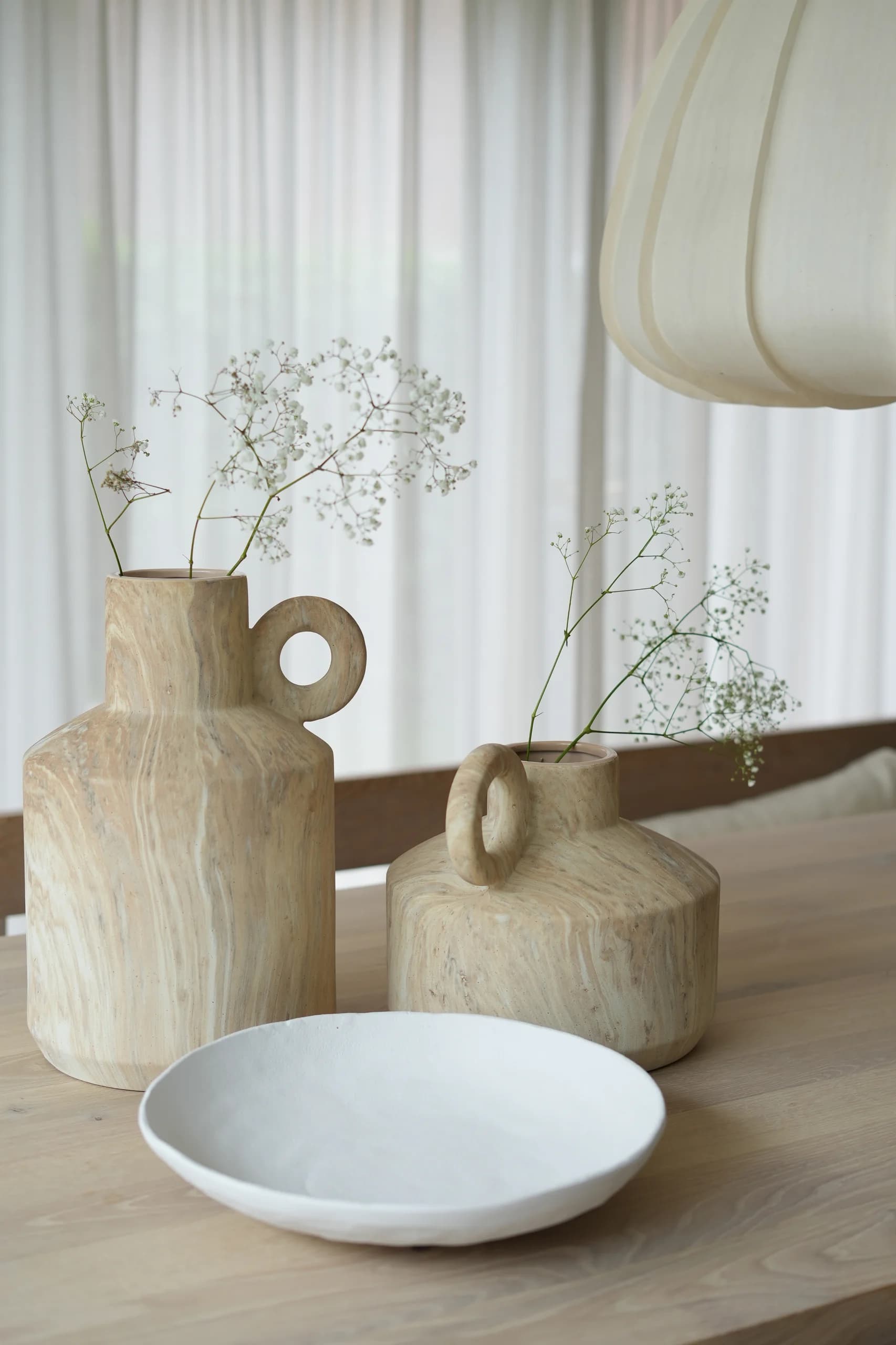 Houten vazen met gipskruid op een eettafel