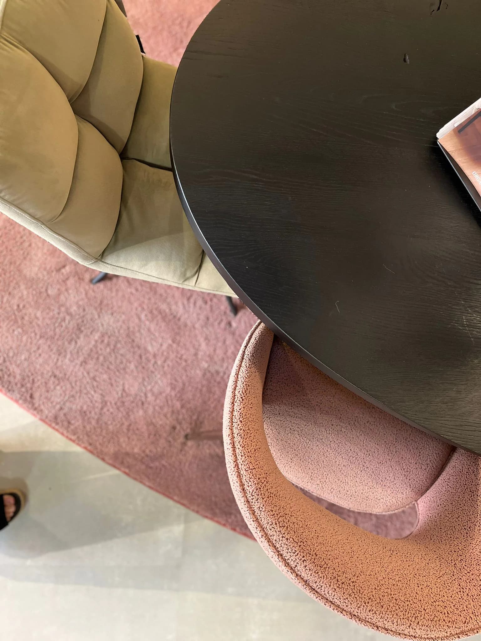 Zwarte eettafel met roze stoel op een rond vloerkleed