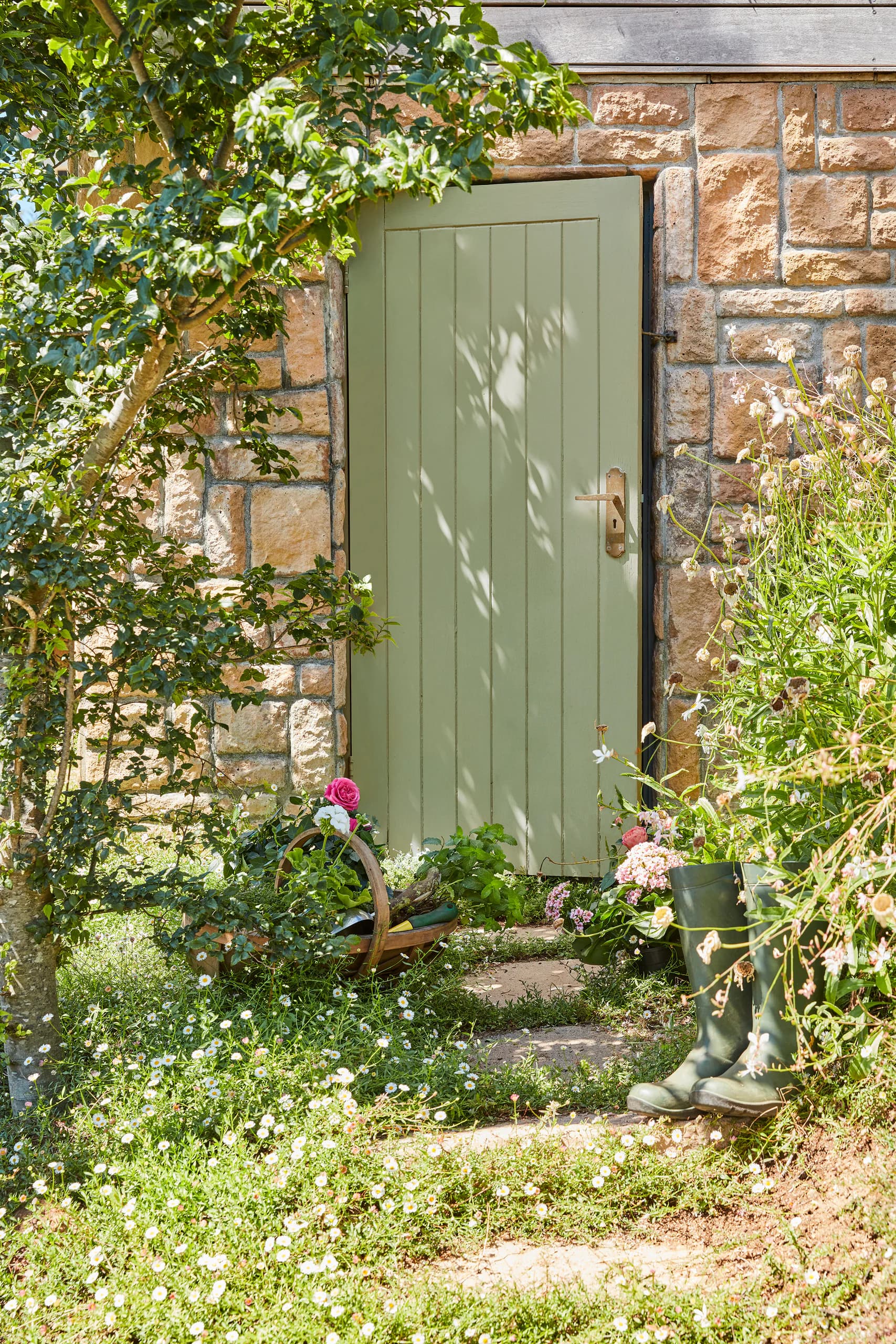 Tuinmuur met groene deur (Boringdon Green) tussen de planten