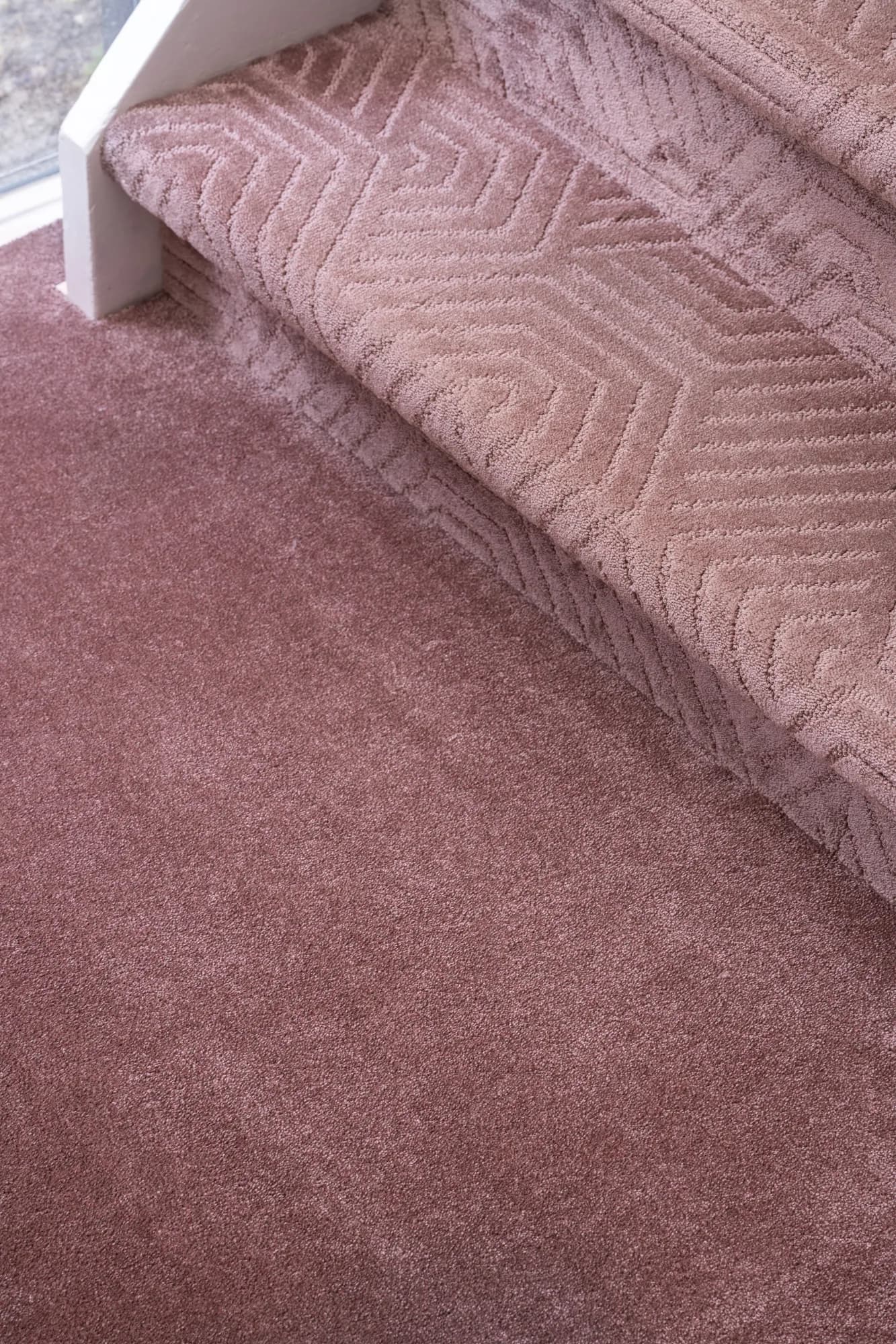 Roze traptapijt van Ambiant met een geometrisch patroon op de treden, van dichtbij