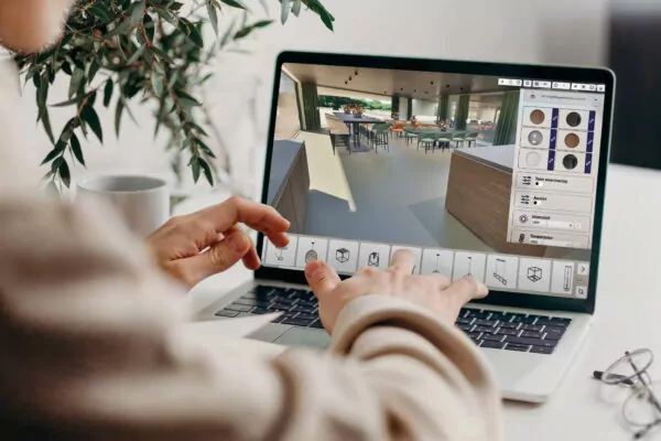 Iemand bekijkt een 3D-ontwerp van een interieur op een laptop
