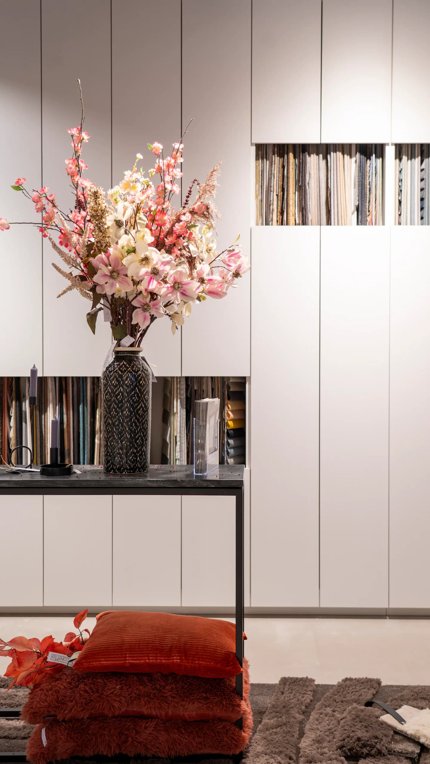 Stoffenwand in de winkel met bloemen en kussens
