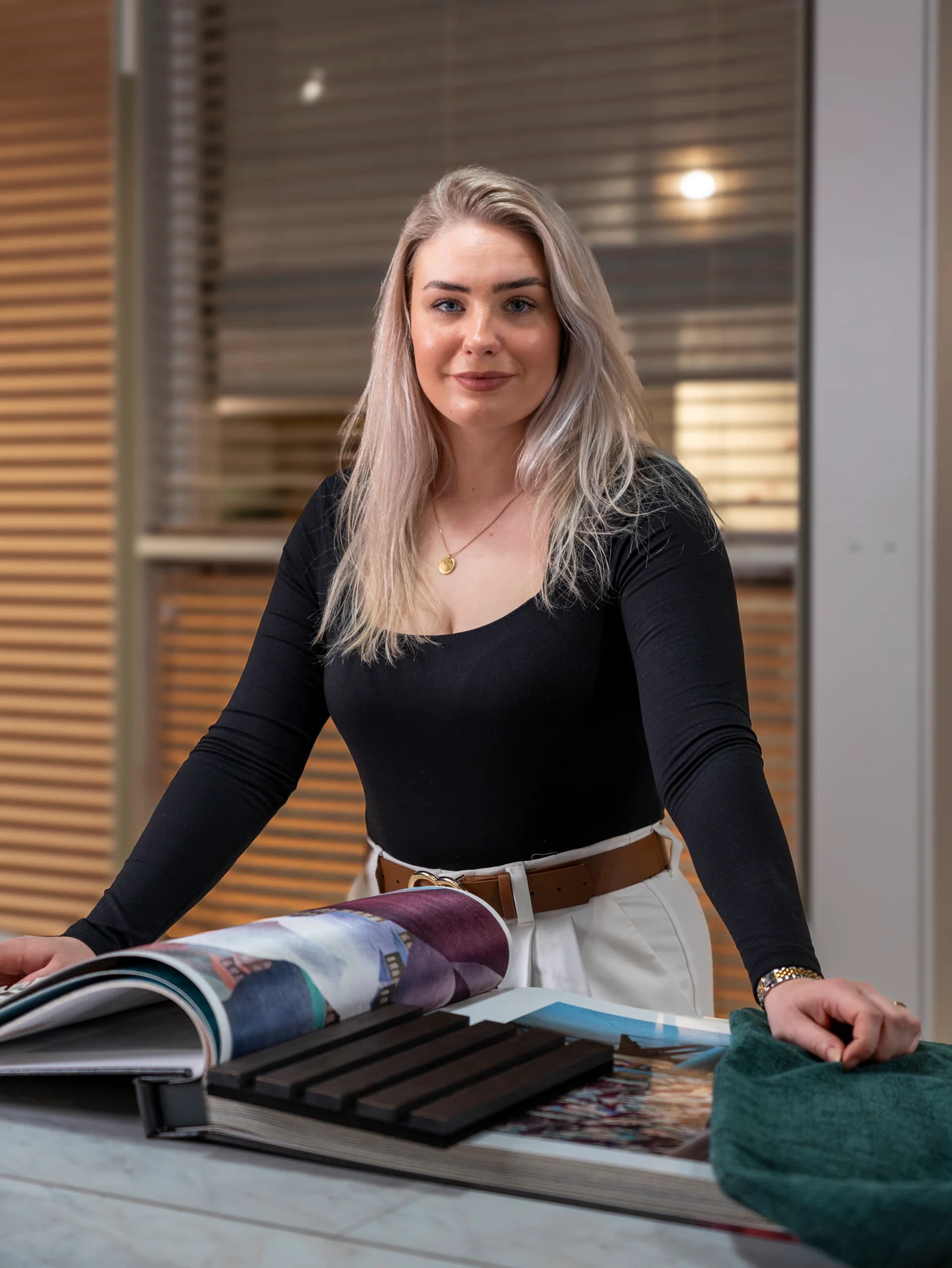 Kirsten aan de ontwerptafel met behang- en stoffenstalen